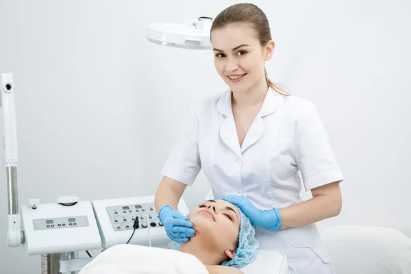 Arzt massiert Mädchen das Gesicht — Stockfoto