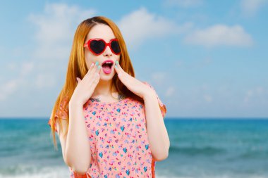 Kalp şeklinde kırmızı güneş gözlüğü ile kız