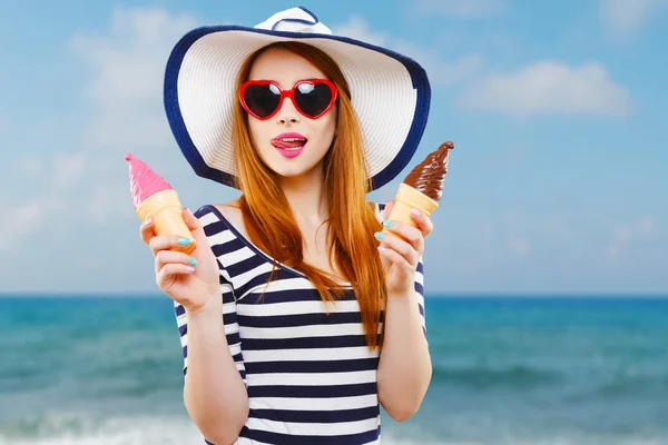 Девушка в шляпе и солнцезащитных очках держит мороженое — стоковое фото