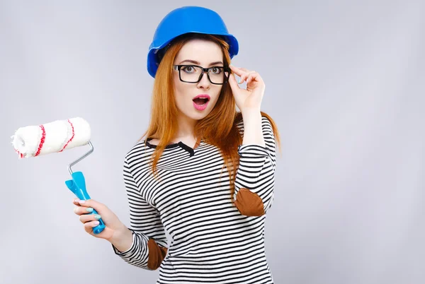 Surprised girl holding brush for painting walls — Stock Photo, Image