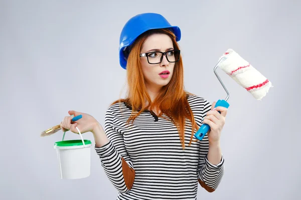 Menina surpresa segurando escova e balde de tinta verde — Fotografia de Stock