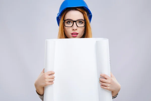 Chica en casco azul sosteniendo hoja de papel —  Fotos de Stock