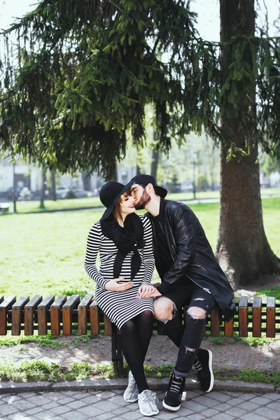 Mannen och gravid flicka sitter på bänken — Stockfoto