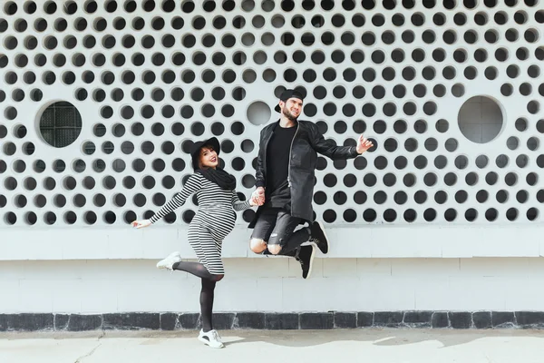 Hombre y mujer embarazada saltando juntos — Foto de Stock