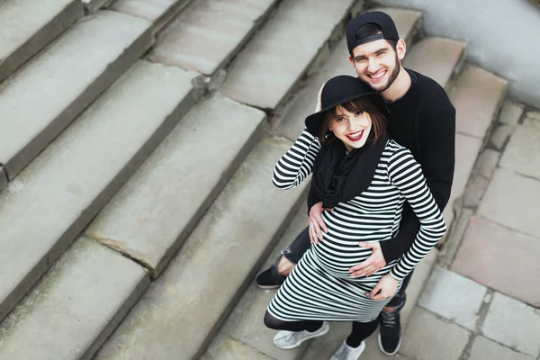 Hombre y chica embarazada de pie en las escaleras — Foto de Stock