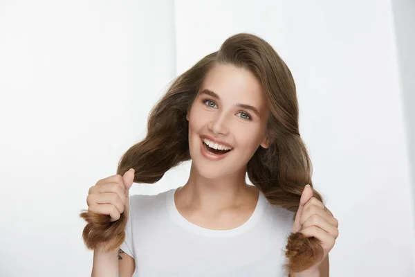 完璧な波状の長い髪を持つ美しい女の子は カメラに笑みを浮かべて 超健康的な素晴らしい髪のカール幸せ白に隔離された女性 — ストック写真
