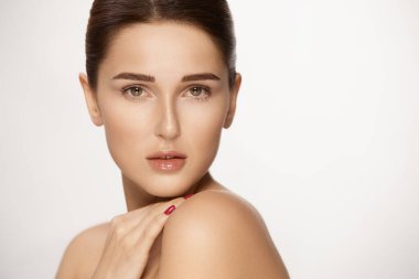 Beyaz tenli şehvetli bir kadın, güzel bir kadın omuzlarına dokunuyor ve kameraya bakıyor.