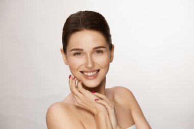 Taze tenli ve parlak saçlı mutlu genç bayan kameraya gülümseyen şehvetli sağlıklı kadın.