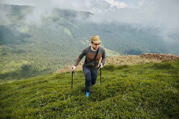 Άνθρωπος Πεζοπορία Στύλους Αναρρίχηση Στην Κορυφή Του Λόφου Γεμάτο Πράσινο — Φωτογραφία Αρχείου