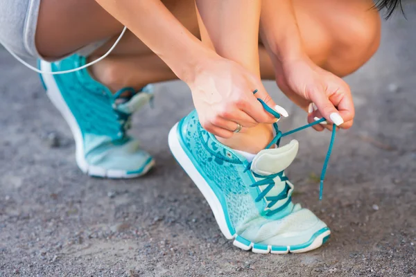 Deportiva mujer atando cordones de zapato antes de correr — Foto de Stock