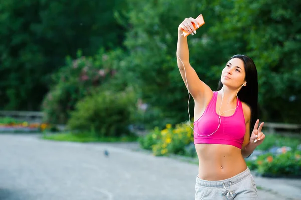 Mulher desportiva tirar selfie e ouvir música com fones de ouvido — Fotografia de Stock