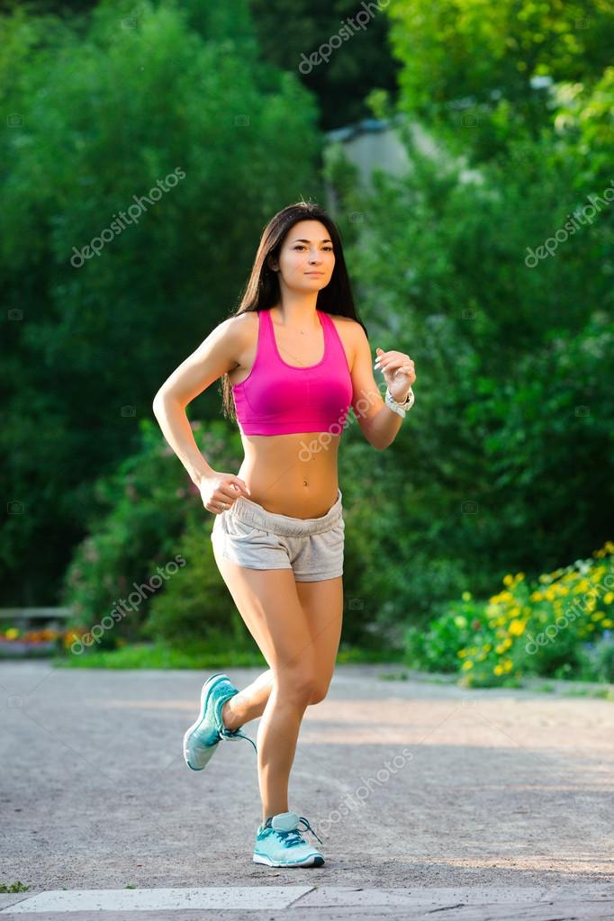Pretty fitness woman, jogging in the green park Stock Photo by