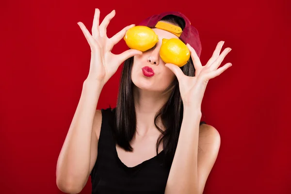 Pretty woman holding two oranges in front of her face — Stock Fotó