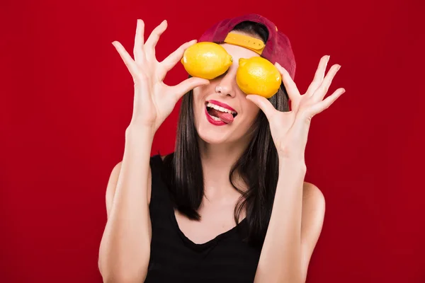 Cheerful woman holding two oranges in front of her face — Stock Fotó