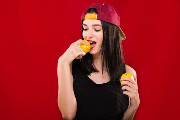Beautiful brunette girl, posing with two lemons in studio — Stock Fotó