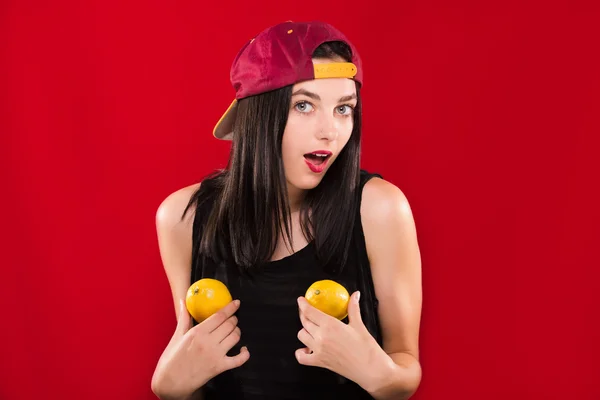 Charming young girl, posing with two lemons in studio — 스톡 사진