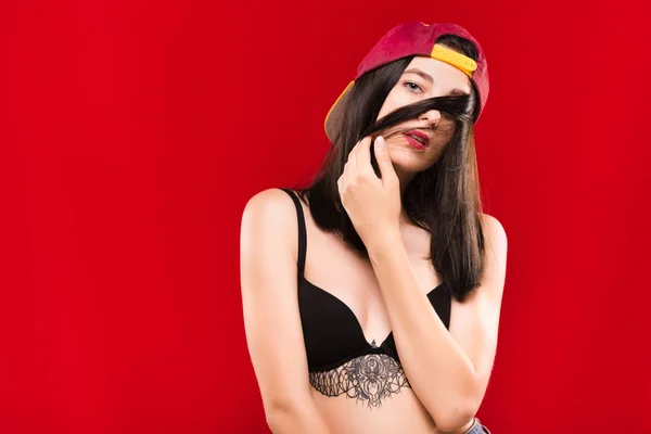 Beautiful young woman posing on the red background, in studio — 스톡 사진