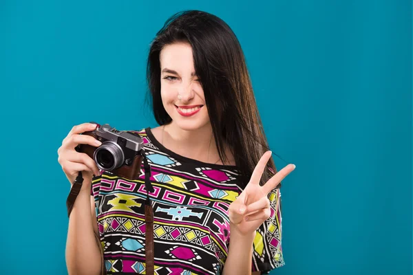 Cheerful woman holding retro camera in her hand and smiling — 스톡 사진