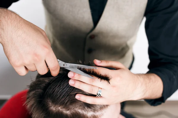 Barber giving a new haircut — стокове фото