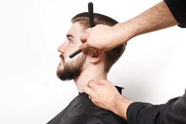 Hairdresser shaving young man — Stock Photo, Image