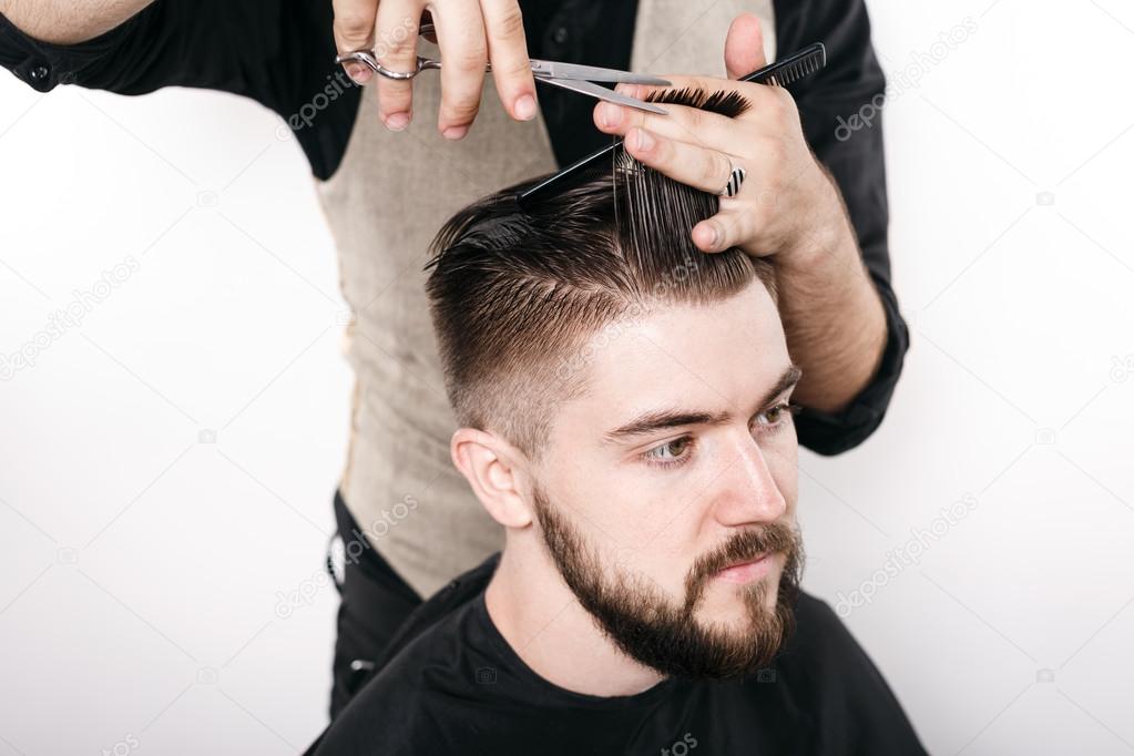 Hairdresser shaving young man