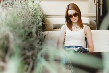 kız kanepede oturan ve bir kitap okuma