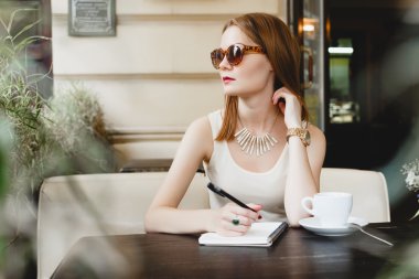 Bej deri koltukta oturan güzel genç kız