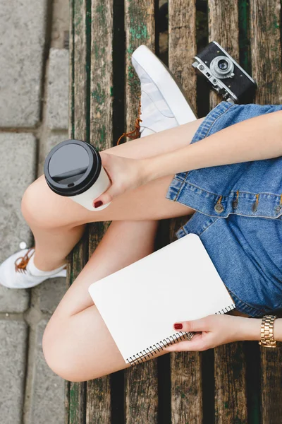 Kahve ile bir bankta oturan kadın — Stok fotoğraf