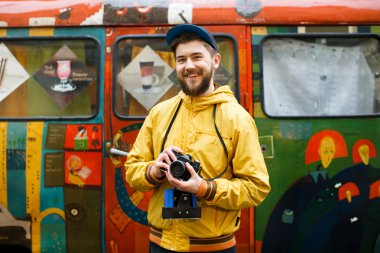 Kameraya bakıyor ve gülüyor hipster