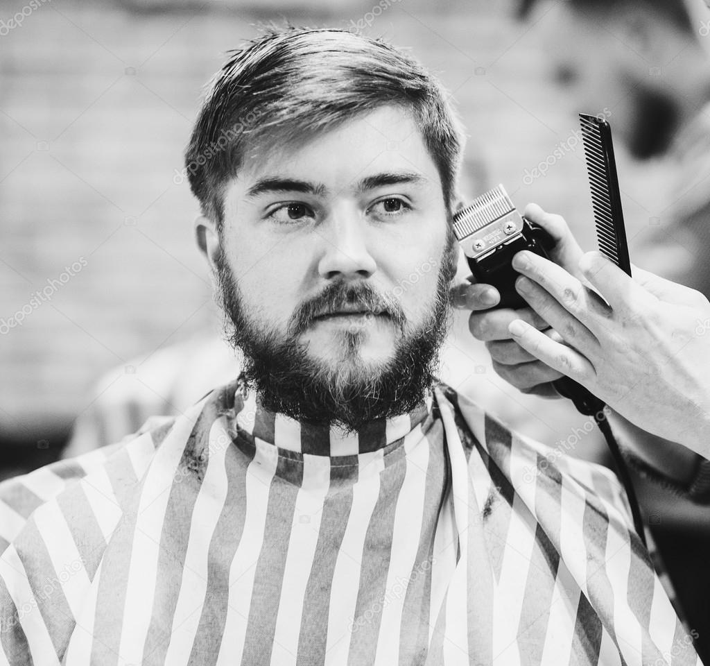 Barber cutting bearded guy
