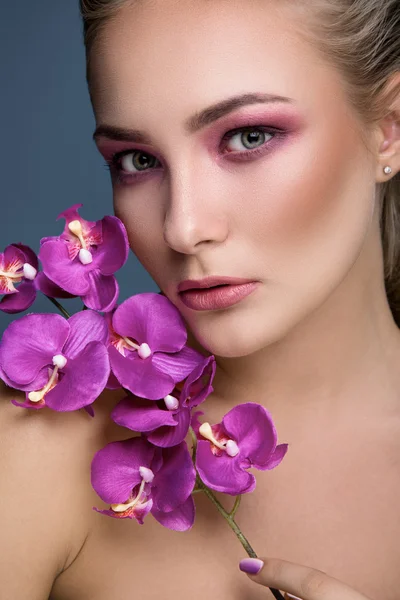 Mujer rubia sosteniendo orquídea —  Fotos de Stock