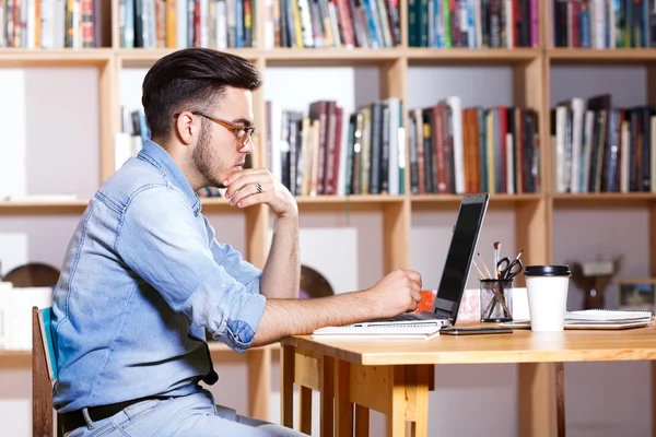 Un hombre serio sentado a la mesa — Foto de Stock