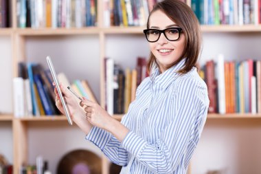 Tablet üzerinde çalışan gülümseyen kadın