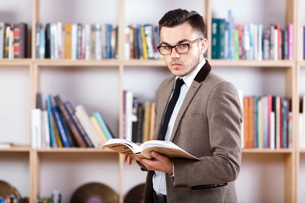 Ung man poserar med en bok i office — Stockfoto