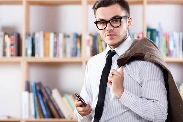 Mann posiert mit Smartphone im Büro — Stockfoto