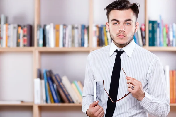 Ernstige brunette man poseren met glazen en digitale tablet — Stockfoto