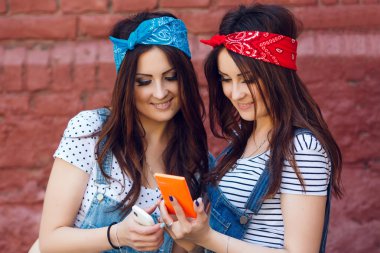 twins girls looking at smart phone