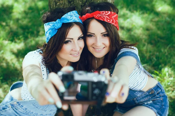 Девушки-близнецы делают селфи с камерой — стоковое фото