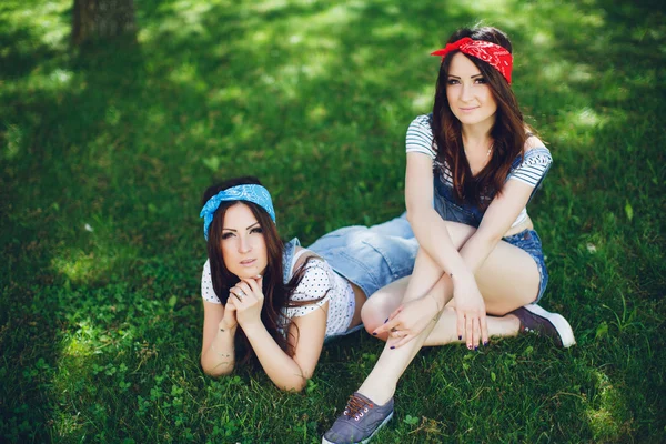 Twins girls lying on the grass in park — ストック写真