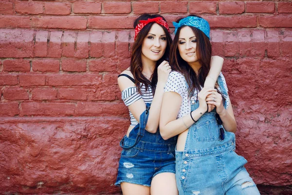 Chicas gemelas abrazándose frente urbano de la pared del fondo de la. —  Fotos de Stock