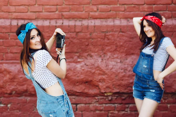 Zwillinge Mädchen posiert auf Ziegelwand — Stockfoto
