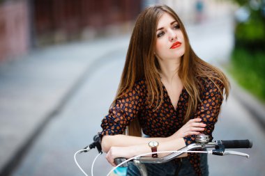 Beautiful girl with bicycle thinking