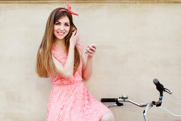 Young woman smiling and holding smartphone — Φωτογραφία Αρχείου