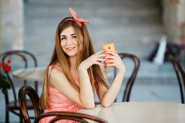 Dziewczyna trzyma telefon i patrząc na kamery — Zdjęcie stockowe