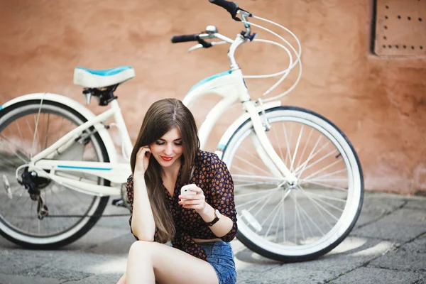 Menina bonita sentada no pavimento — Fotografia de Stock