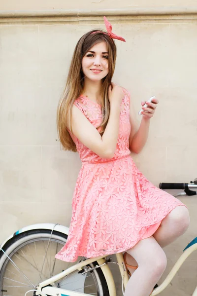 Девушка сидит на велосипеде с мобильного телефона . — стоковое фото