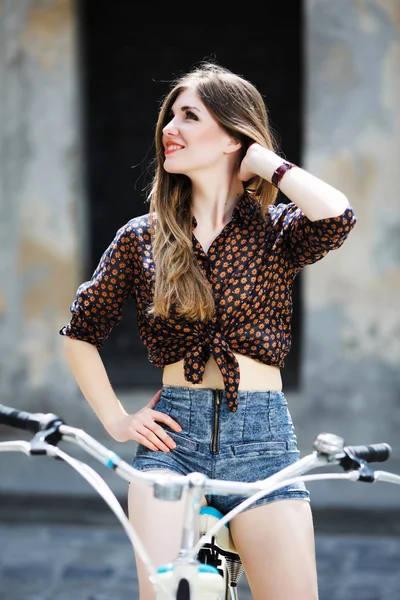 Приваблива молода дівчина з велосипедом — стокове фото