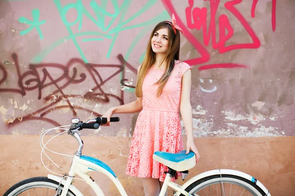 Молодая девушка улыбается с велосипедом — стоковое фото
