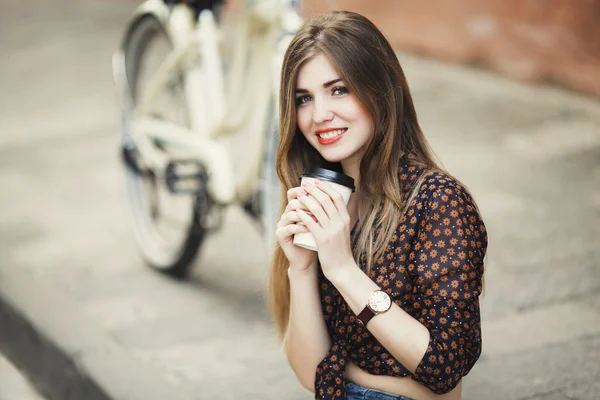 Menina bonito está bebendo café no pavimento de azulejos na cidade velha — Fotografia de Stock