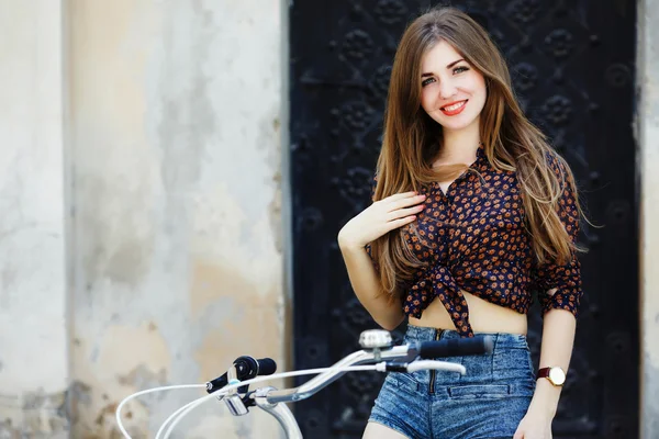 Attractive young girl with bicycle — Stock Photo, Image